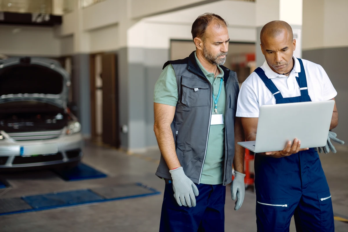 Technicians reviewing a job in a Plutoo workshop